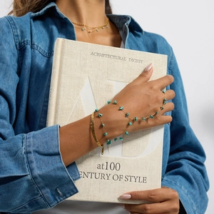 Model wearing a double-layer stainless steel hand chain with turquoise and a gold bangle