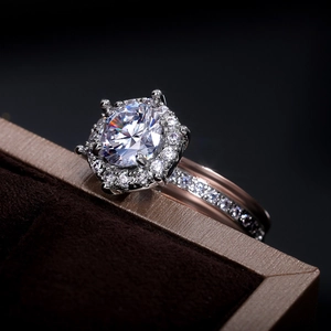 Close-up of rose gold halo ring with large round zircon and side pavé diamonds