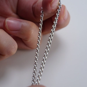 Detailed view of hand-held 925 silver rope chain necklace with polished twisted links