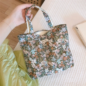 Détail du sac cabas en coton fleuri avec étiquette Simple Wish et poignées