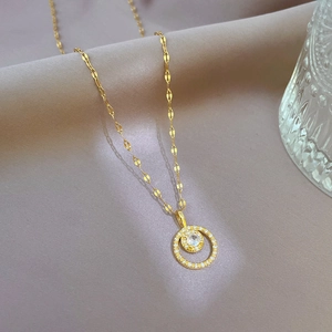 Detail of gold necklace with double circle pendant and sparkling zircon inlay
