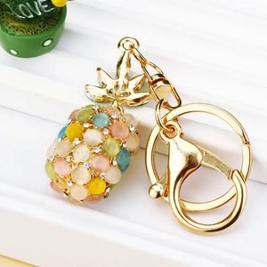Close-up of golden pineapple keychain featuring opal stones and sparkling crystals