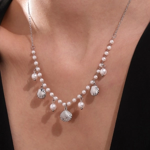 Elegant 18k gold plated shell and pearl beaded necklace worn by a fashion model