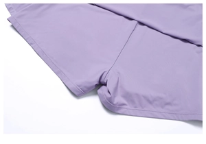 Macrodetail van lila yoga-skort met elastische dubbelnaaldstiksels en stoftextuur