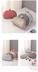 Detailed view of pearl-rimmed shell evening bag with glitter surface and metal clasp