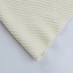 Gros plan détaillé sur le tissu blanc crème de la robe à volants avec texture gaufrée