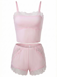 Detail of pink sleepwear set featuring intricate white lace trim on the camisole and shorts