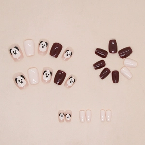 Detail of red and cream press-on nails with cute puppy patterns and glossy finish