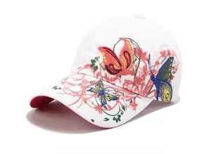 Dettaglio del ricamo a farfalla e fiori con paillettes lucide su cappellino bianco