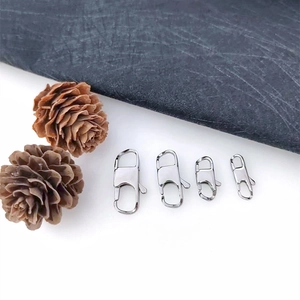 Detail of four silver stainless steel spring lobster clasps in various sizes on slate