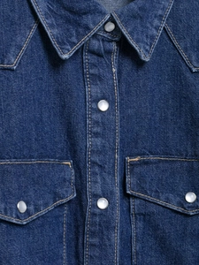 Détail du col de chemise en jean avec boutons-pression en perles et doubles poches