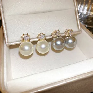 Élégant ensemble de boucles d'oreilles en zircon et perles dorées dans un écrin de luxe