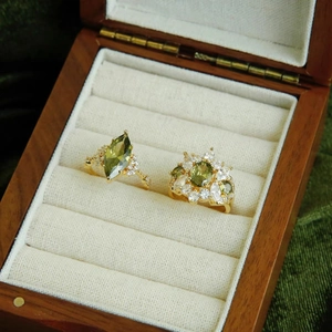 Detail of 14k gold plated oval zircon ring set with olive green and clear stones