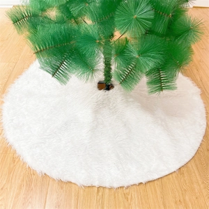 Detail of white long plush Christmas tree skirt on light wood floor with needles