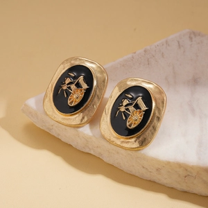Détail de boucles d'oreilles rétro avec relief de rickshaw doré sur émail noir