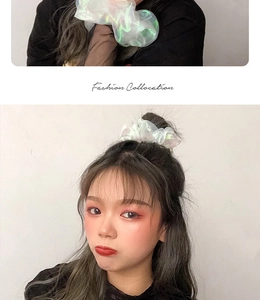 Detailed view of shimmering white iridescent organza scrunchie worn on wrist and hair