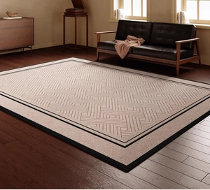 Detail showing the geometric maze pattern and black border on a beige vintage rug