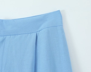 Detailed macro view of the light blue elastic waistband and fine stitching on trousers
