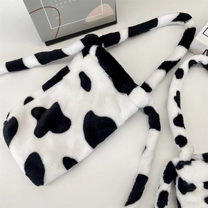 Detail of the soft cow print plush water bottle bag with crossbody strap and fluffy texture