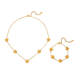 Elegant gold daisy jewelry set with necklace and bracelet featuring brushed matte flowers