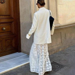 Street style view of the white lace maxi skirt back detail paired with a blazer