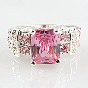 Macro shot of silver ring featuring a large pink rectangular gemstone and pavé settings