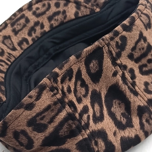 Detailed macro view of the leopard print suede fabric and inner black lining on the beret