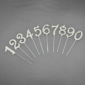 Macro view of silver birthday cake toppers featuring numbers 0-9 with shiny rhinestones