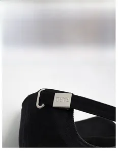 Detailed macro view of adjustable metal buckle with FARD engraving on black baseball cap