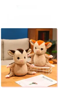 Detail of soft plush sugar glider dolls in brown and orange on a wooden table