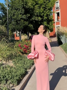 Détail de l'élégante robe longue rose moulante avec des poignets en satin à volants
