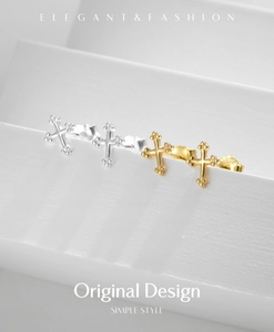 Macro detail of 925 silver and gold cross stud earrings on a clean white background