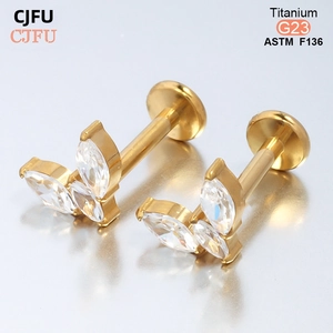 Détail macro d'un clou d'oreille en titane G23 doré serti de zircones blancs marquise