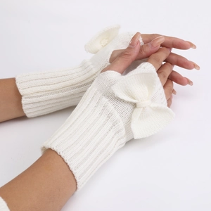 Detailed knit texture of white fingerless gloves featuring a 3D ribbon bow accent