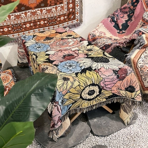 Detail of woven floral camping blanket with bohemian tassels and thick cotton texture