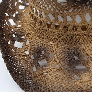 Detailed close-up of ombre woven straw hat featuring intricate hollow cutout textures