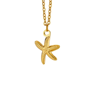 Detailed close-up of a gold starfish pendant necklace with ocean resort style texture