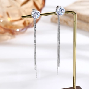 Macro shot of silver tassel earrings featuring sparkling zircon and long snake chains