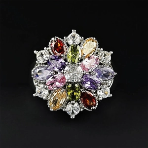 Exquisite flower ring with colorful zircon stones in a silver setting on black background