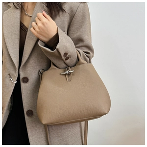 Close-up of khaki leather tote with bamboo toggle closure and pebble grain texture