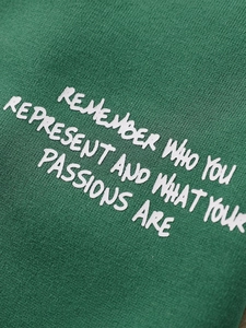 Gros plan d'une veste de baseball verte avec texte de motivation brodé en blanc