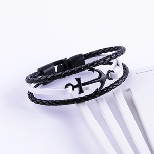 Macro view of woven leather bracelet featuring black metal anchor charm and buckle