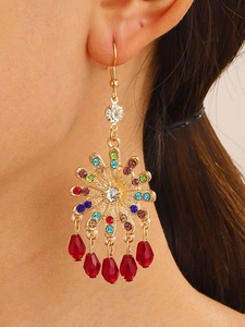 Detail of bohemian drop earrings with multicolor rhinestones and red teardrop beads