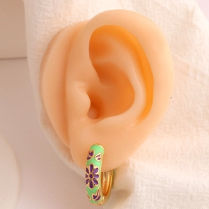 Golden enamel flower hoop earrings with purple floral patterns on green base