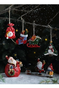 Detailed view of resin Christmas ornaments featuring Santa and Snowman in a winter scene
