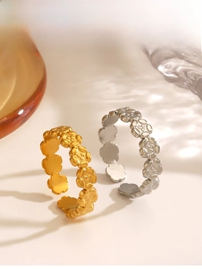 Detailed view of 18K gold and silver floral rings with adjustable open band design