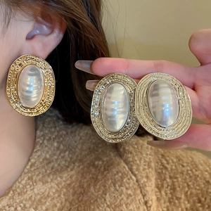 Vintage oversized gold oval earrings with large white pearls for a classy French style