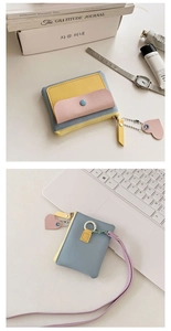 Detail of macaron color block mini wallet featuring heart charm and wristlet strap