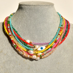 Detail of colorful beaded necklace with freshwater pearls and evil eye charm pendant