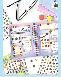 Flat lay of colorful DIY journal stickers with cartoon food themes on white desk